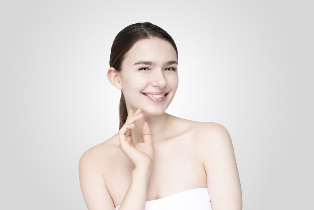 asian young woman touching face with relaxed expression